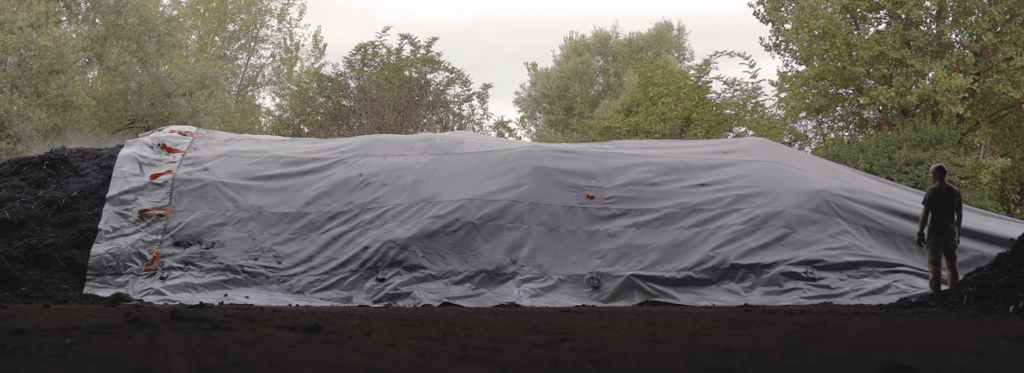 halbdurchlässige Membran wird von der Kompostierungsmiete gezogen